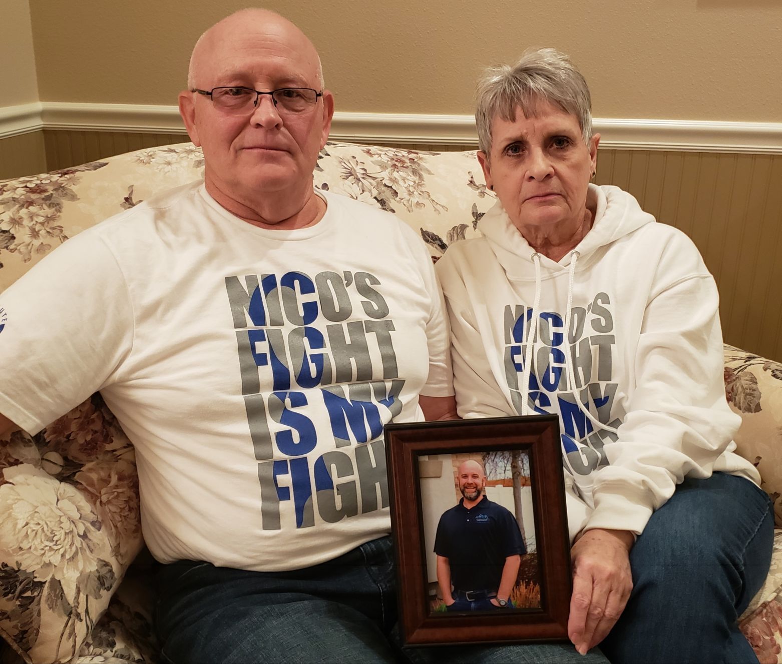 Kim and Shauna Quick holding photo of Lance (2021 story)